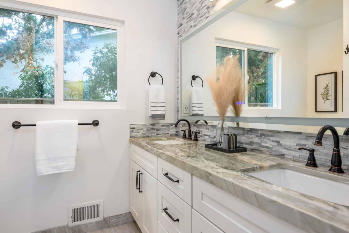 1420 South Mary Avenue Sunnyvale, CA 94087 - Photo 17 of 24 a bathroom with double vanity sink a window and a mirror