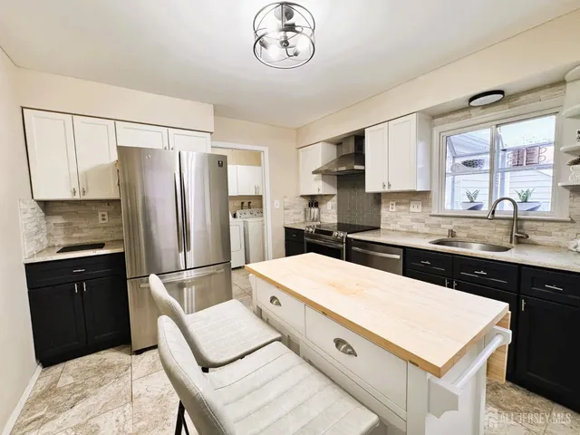 a kitchen with stainless steel appliances a refrigerator sink and stove