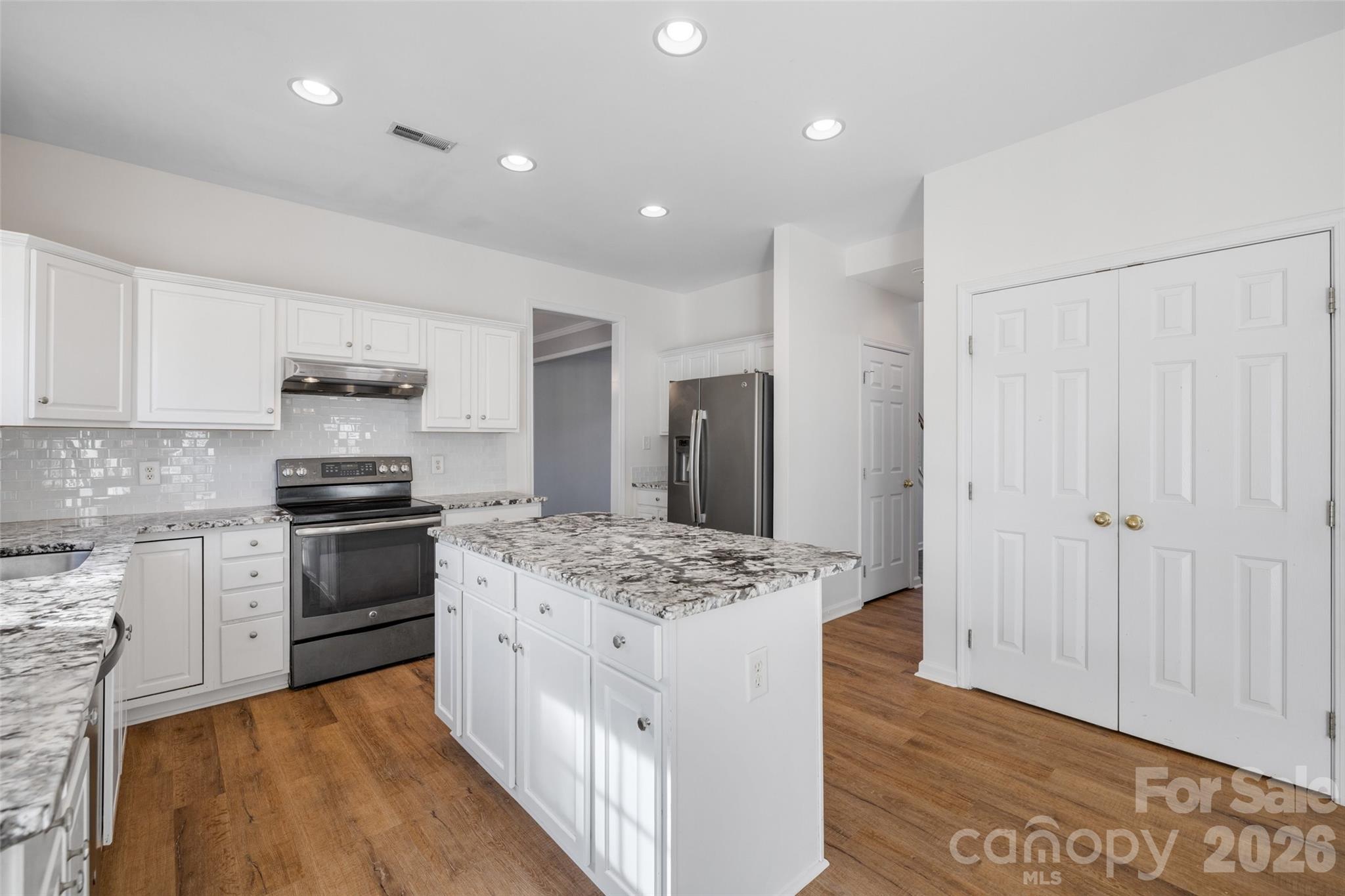 813 Circle Trace Road Monroe, NC 28110 - Photo 15 of 37 a kitchen with stainless steel appliances kitchen island granite countertop a stove and a refrigerator