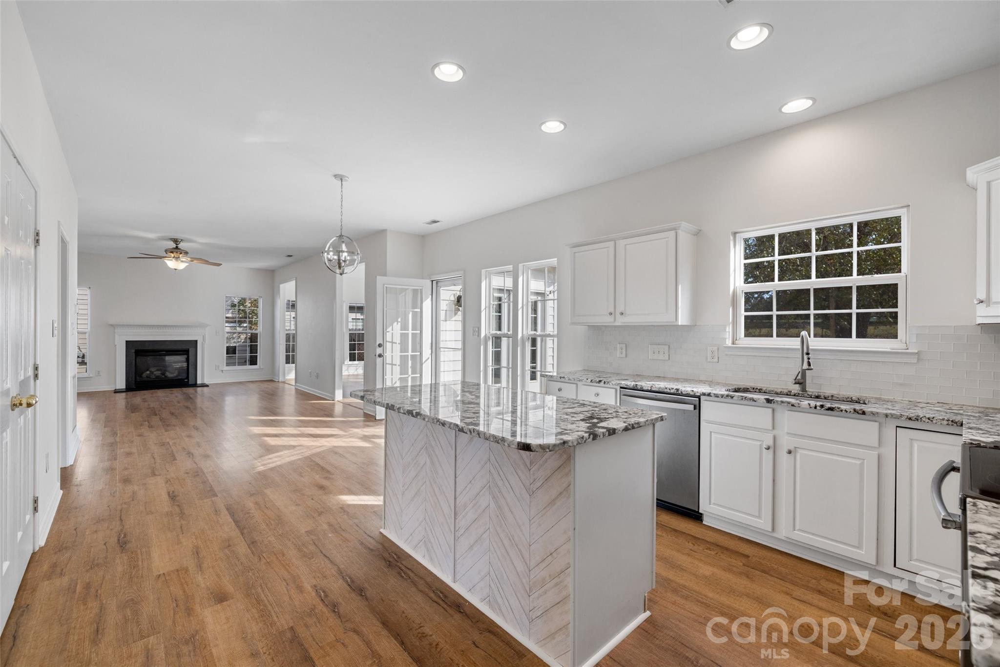 813 Circle Trace Road Monroe, NC 28110 - Photo 6 of 37 a kitchen with stainless steel appliances granite countertop a stove a sink dishwasher and a refrigerator with wooden floor