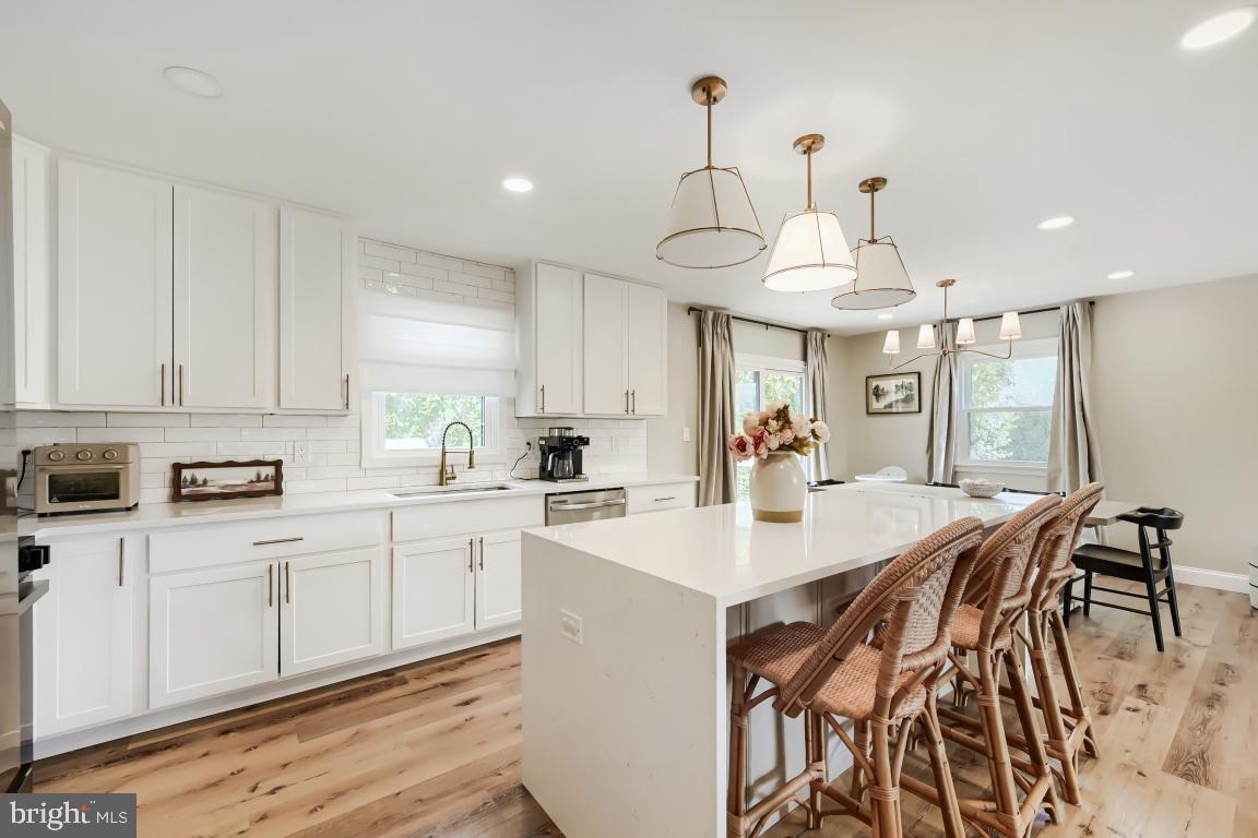 600 East Macphail Road Bel Air, MD 21014 - Photo 12 of 37 a kitchen with stainless steel appliances kitchen island granite countertop a sink a stove a refrigerator and white cabinets with wooden floor