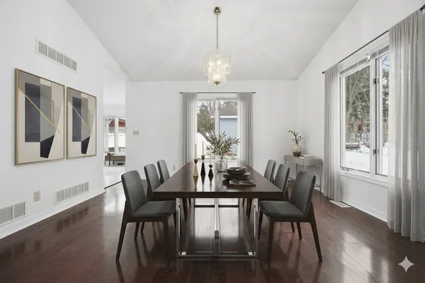 a view of an empty room with wooden floor and windows