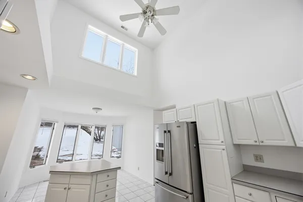 a kitchen with white cabinets a sink stove and refrigerator