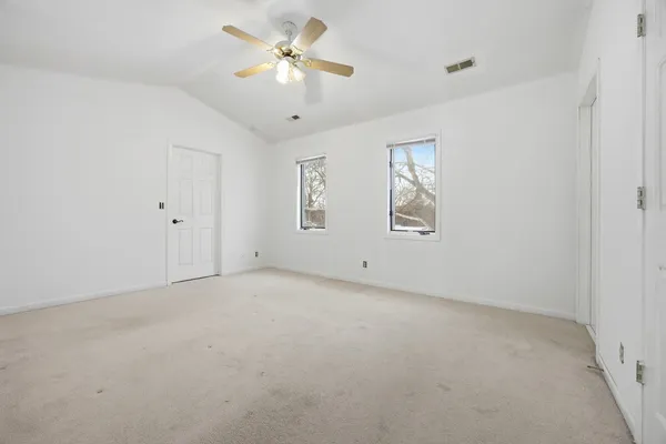 a bedroom with a bed mirror and a window