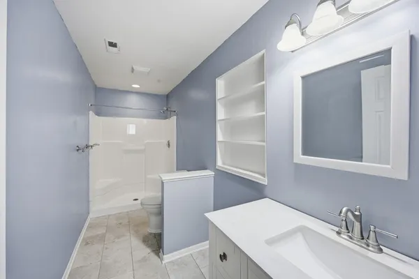 an empty room with windows and fan
