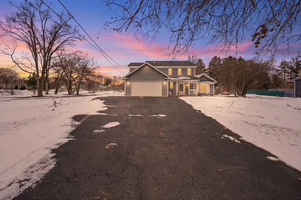 a front view of a house with a yard covered in snow