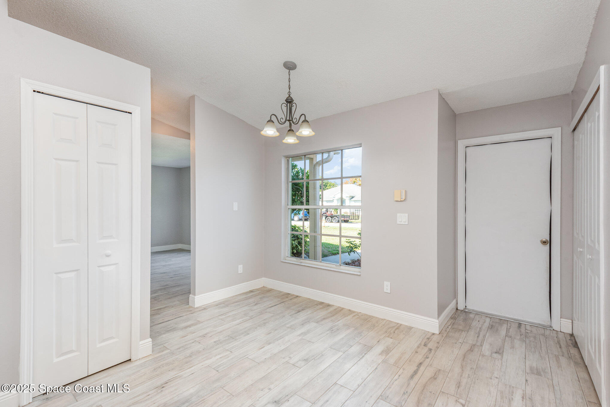 1045 Jacaranda Circle Rockledge, FL 32955 - Photo 11 of 32 an empty room with wooden floor and windows