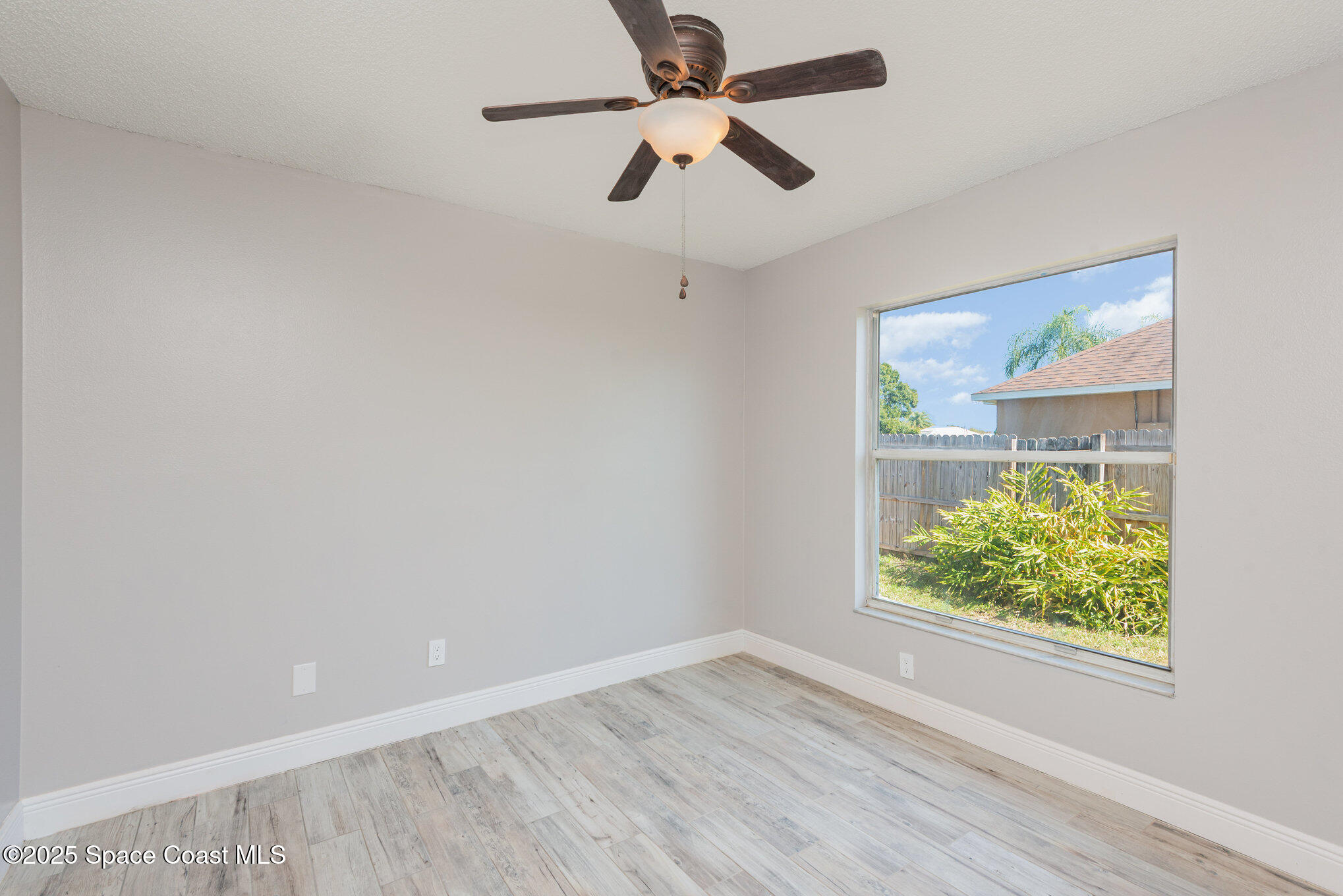 1045 Jacaranda Circle Rockledge, FL 32955 - Photo 18 of 32 an empty room with a window and a ceiling fan