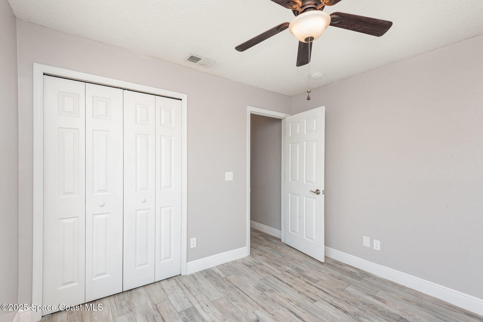 1045 Jacaranda Circle Rockledge, FL 32955 - Photo 19 of 32 wooden floor in an empty room with a window