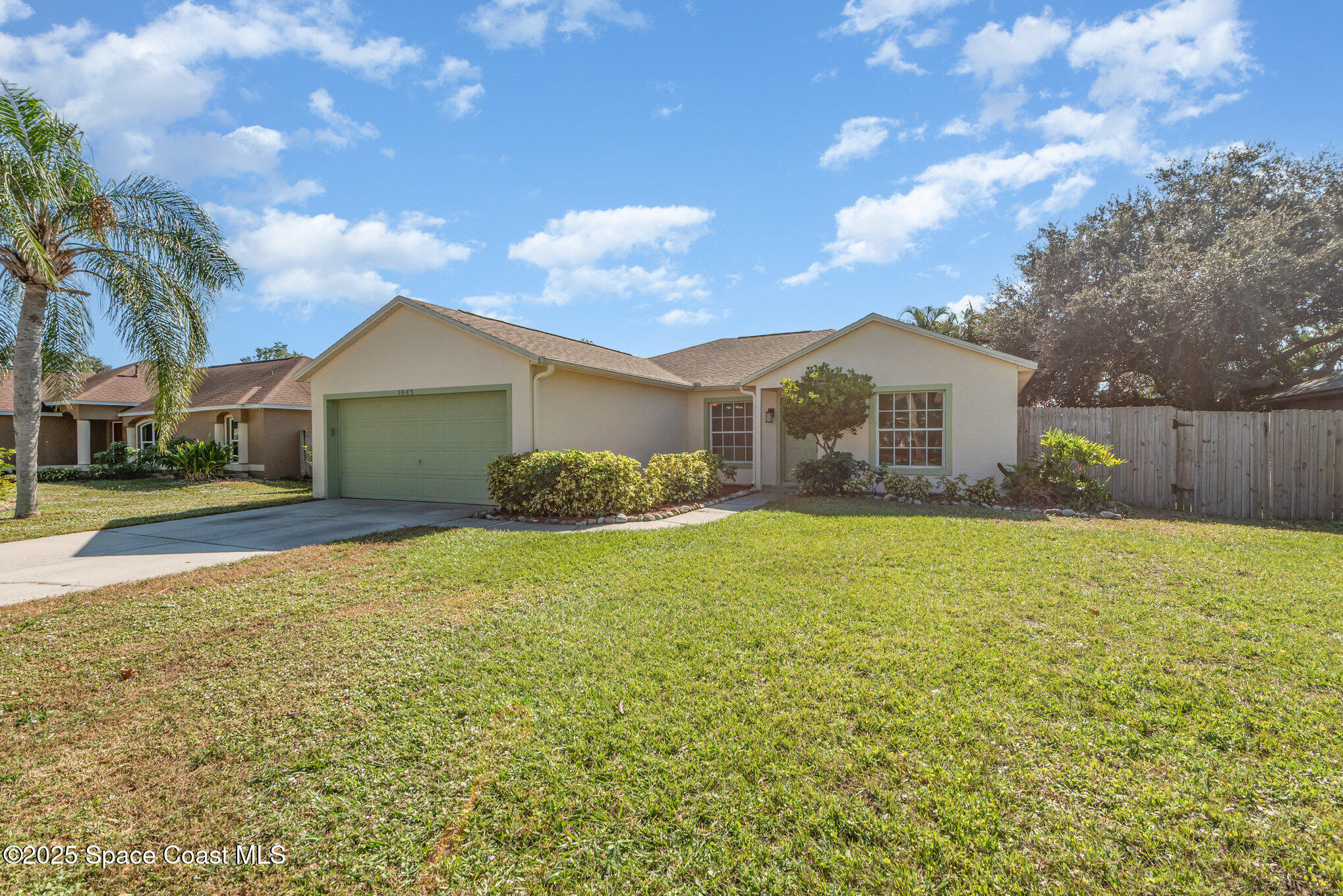 1045 Jacaranda Circle Rockledge, FL 32955 - Photo 2 of 32 a house view with swimming pool and tall trees