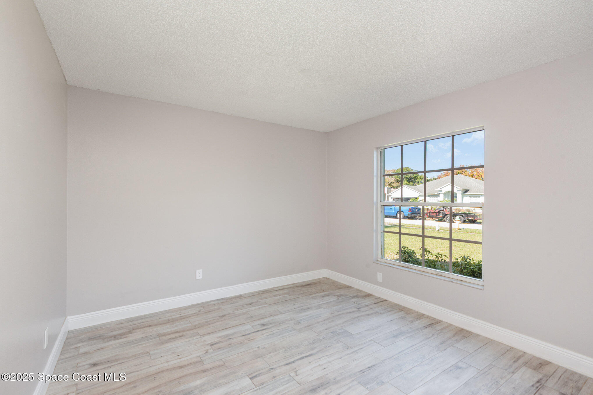 1045 Jacaranda Circle Rockledge, FL 32955 - Photo 3 of 32 an empty room with wooden floor and windows