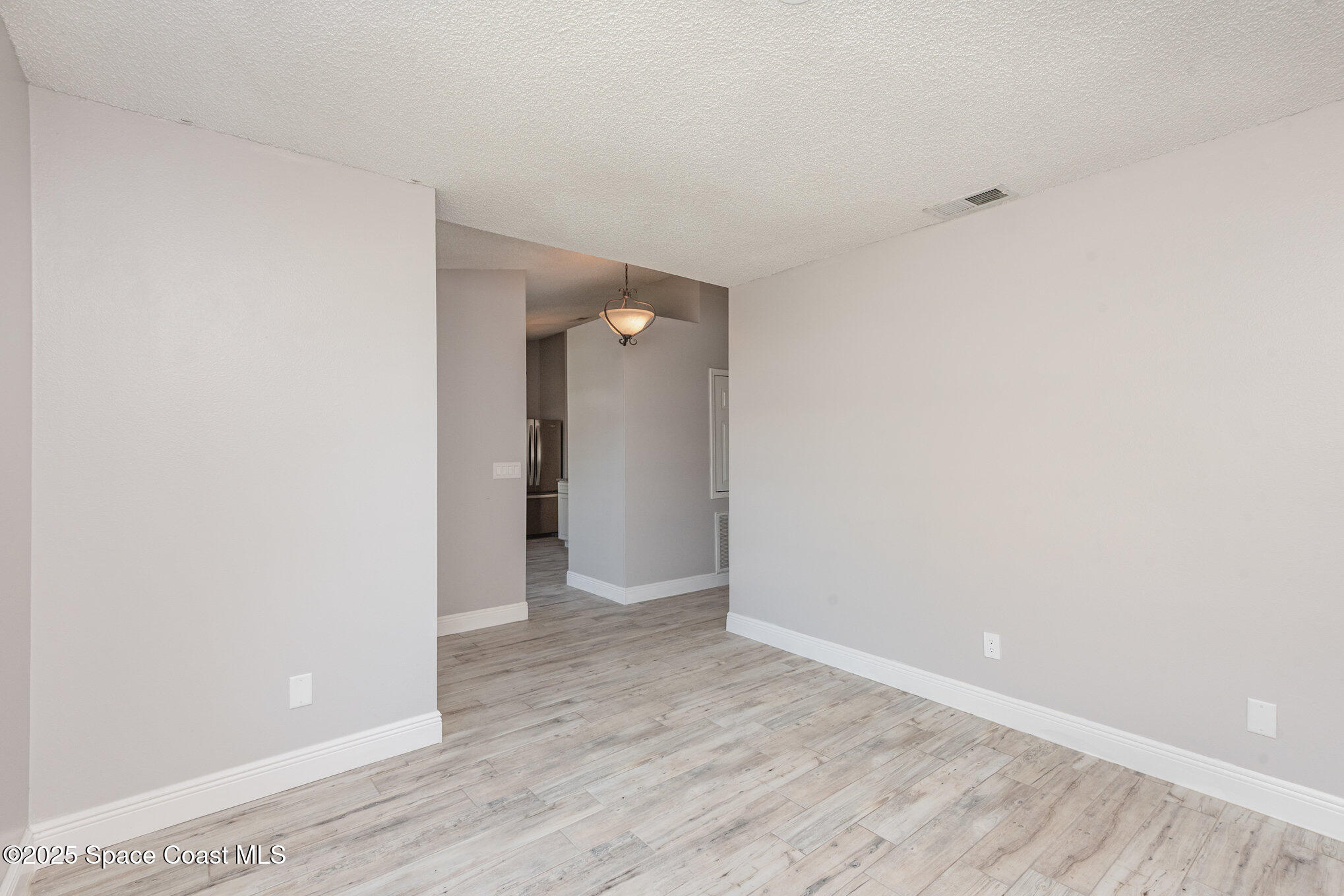 1045 Jacaranda Circle Rockledge, FL 32955 - Photo 4 of 32 a view of an empty room with wooden floor