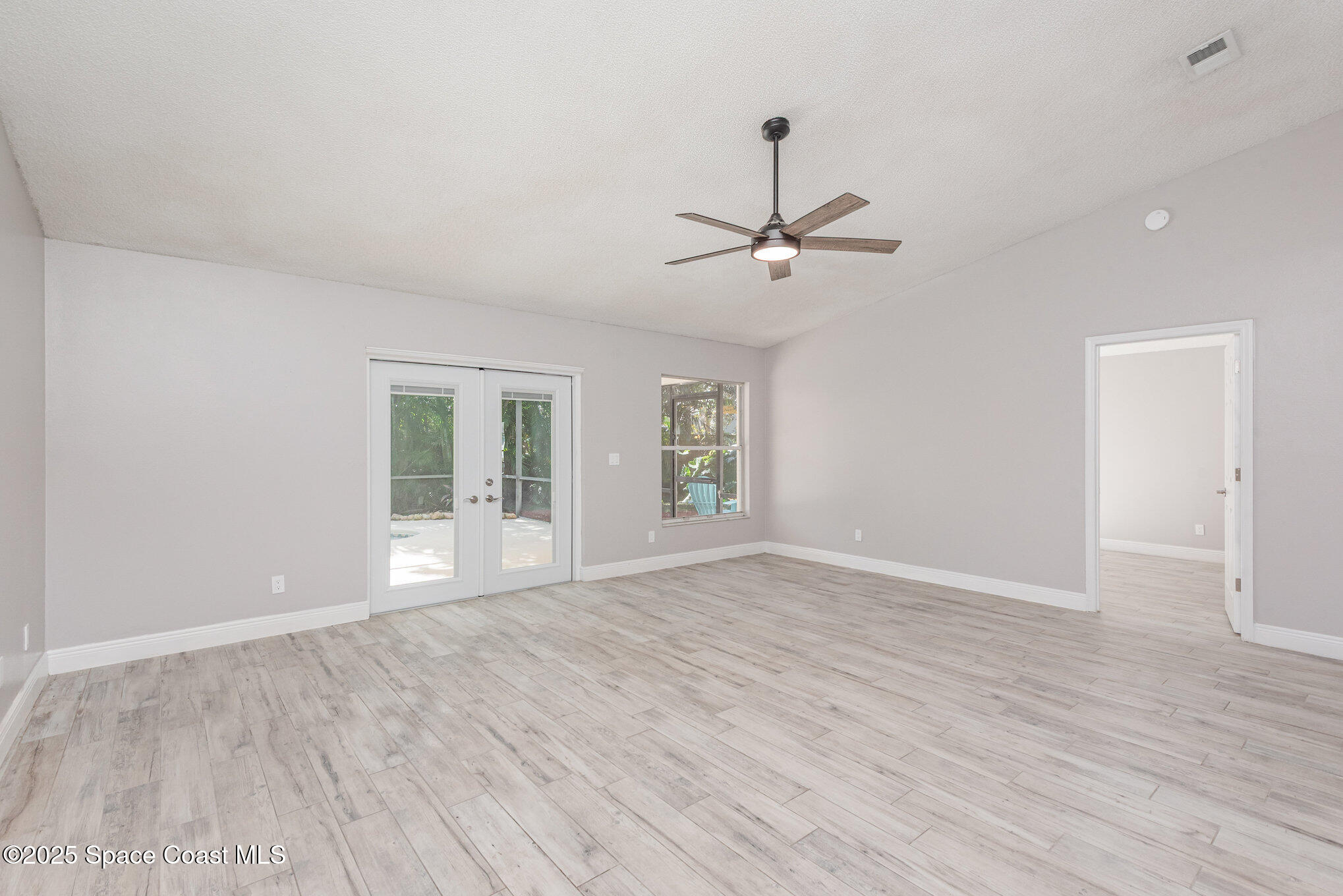 1045 Jacaranda Circle Rockledge, FL 32955 - Photo 5 of 32 a view of an empty room with a window and wooden floor