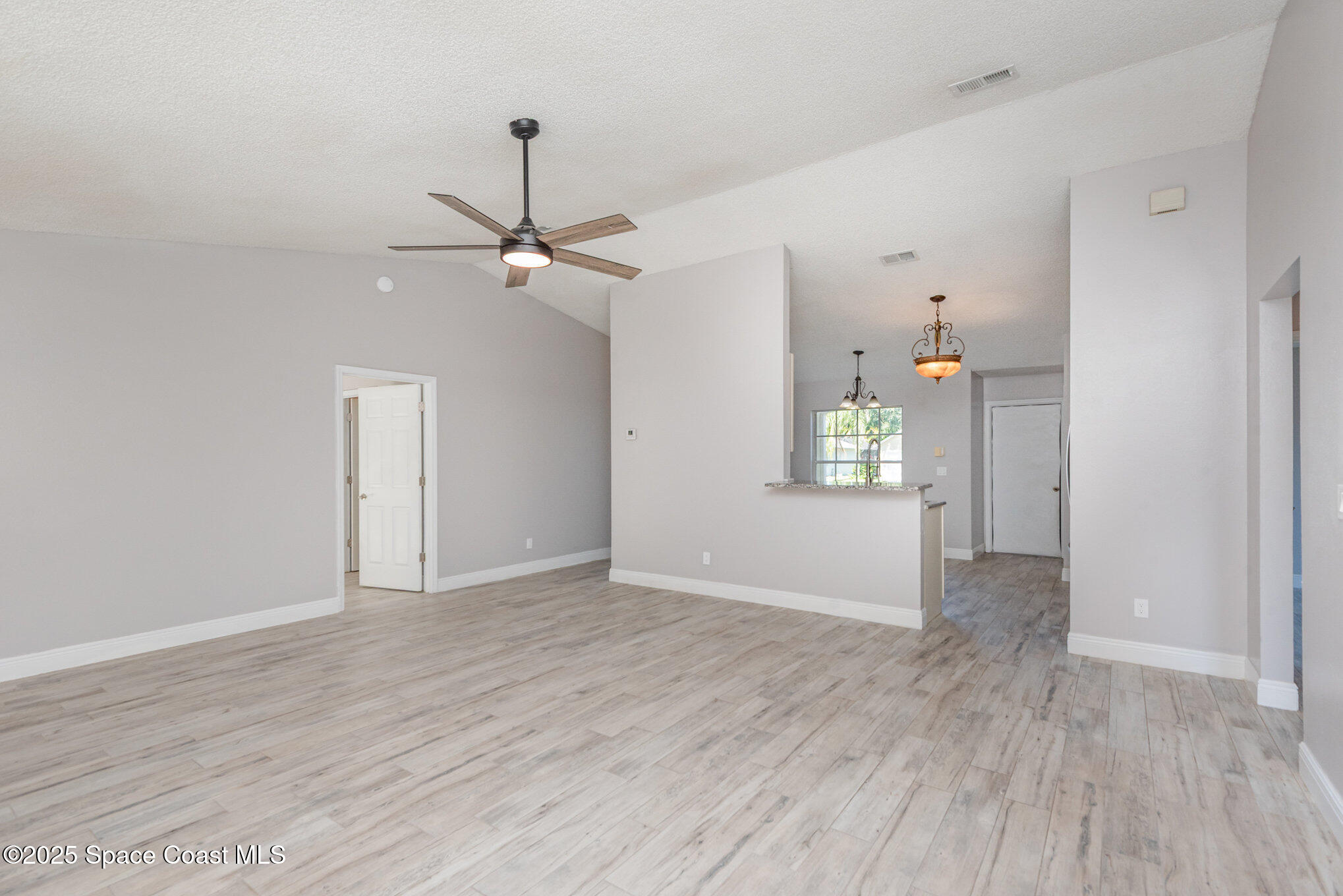 1045 Jacaranda Circle Rockledge, FL 32955 - Photo 6 of 32 wooden floor in an empty room with a window