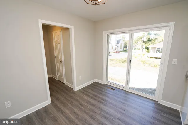 an empty room with wooden floor and a window