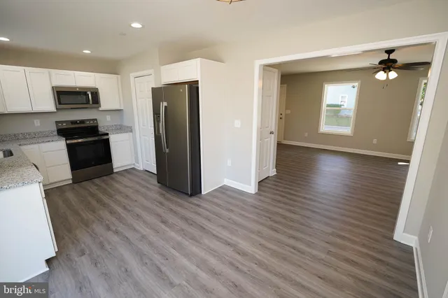 a kitchen with stainless steel appliances a refrigerator and wooden floor