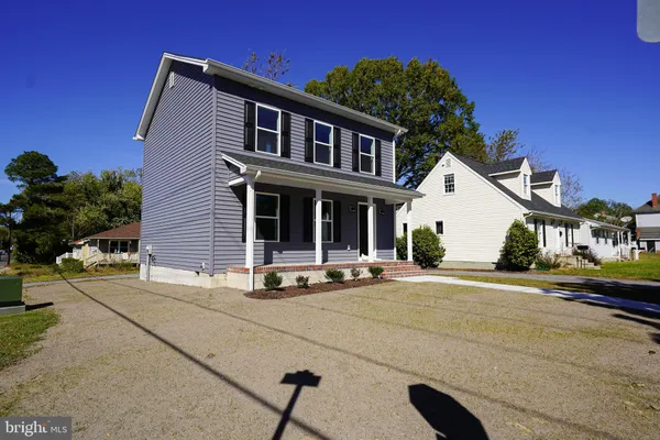 a front view of a house with yard and outdoor seating