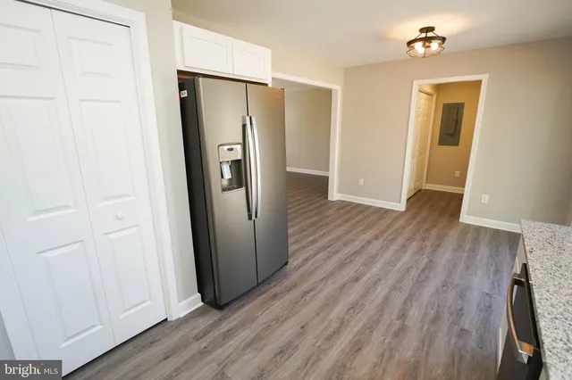 an empty room with wooden floor and a bathroom