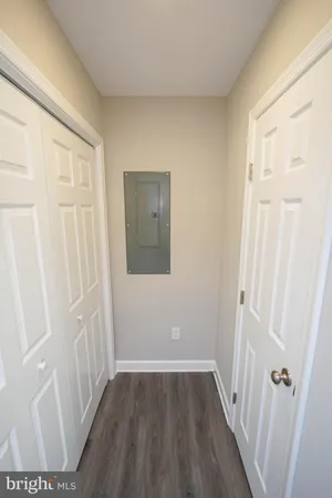 a view of a hallway with wooden floor and closet area