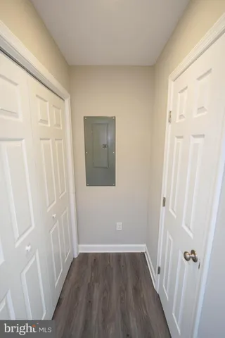 a view of a hallway with wooden floor and closet area