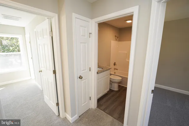 a view of a bathroom with a hardwood floor and a view of a bathroom