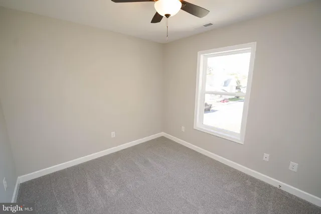 an empty room with a chandelier fan