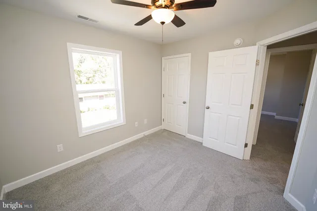 a bathroom with a granite countertop bathtub shower sink mirror vanity and toilet