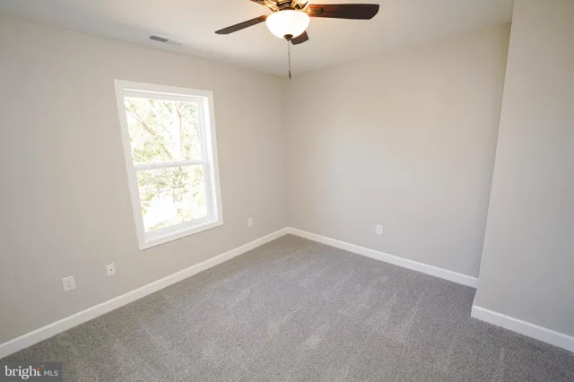 an empty room with a chandelier fan