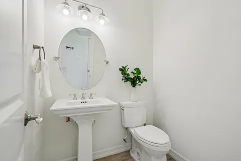 a view of a dining room with furniture a potted plant and a floor to ceiling window