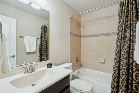 an empty room with windows and chandelier fan