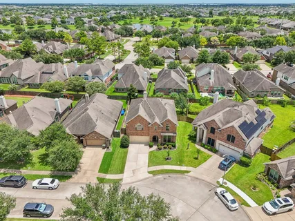 a view of a yard in front of a brick house with a big yard