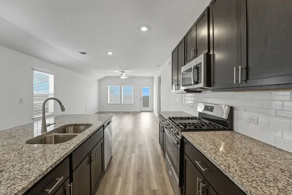 a kitchen with granite countertop stainless steel appliances window a sink and cabinets