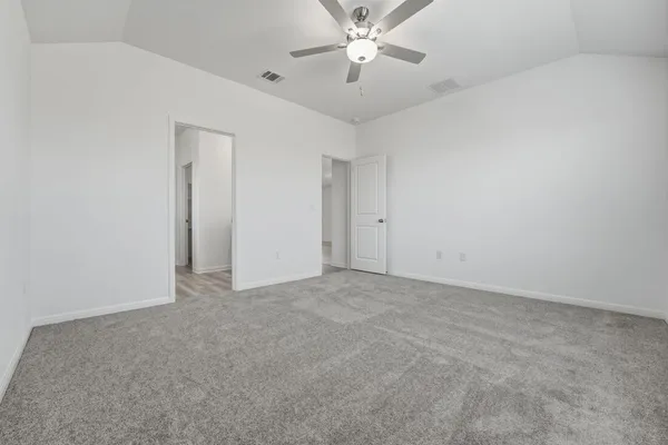 a view of an empty room and chandelier fan