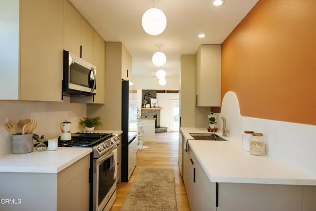 a kitchen with stainless steel appliances granite countertop a stove a sink and a refrigerator