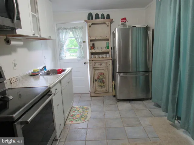 a kitchen with refrigerator and cabinets