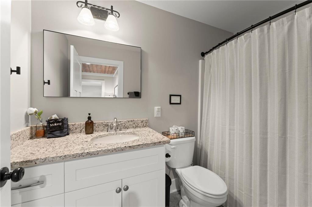 1320 Preacher Campbell Road Clarkesville, GA 30523 - Photo 22 of 36 a bathroom with a granite countertop sink vanity mirror and toilet