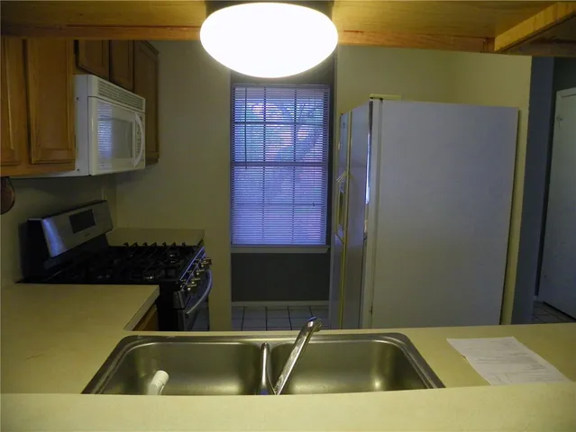 a view of a kitchen with a sink and a refrigerator