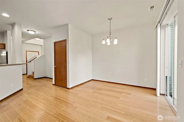 a view of a room with wooden floor staircase and a ceiling fan