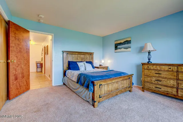 a bed sitting in a room next to a lamp