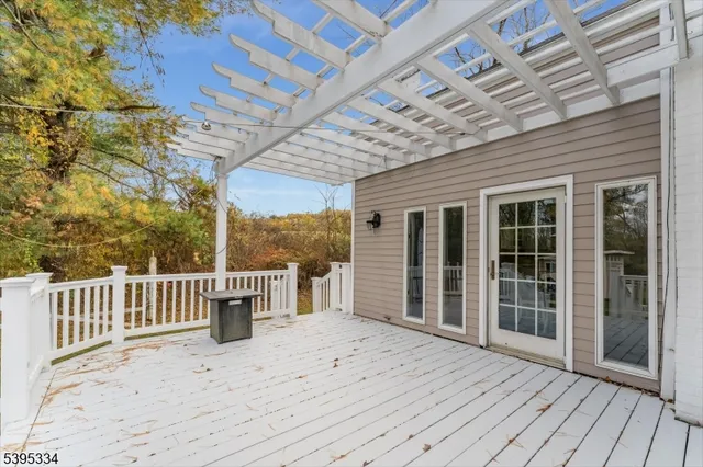 a porch with wooden floor and fence next to a yard
