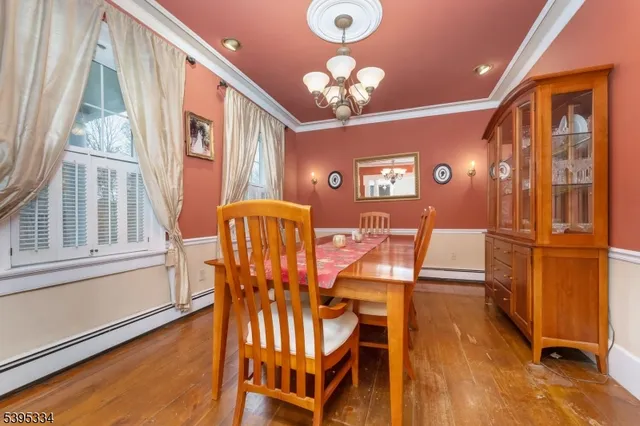 a view of a dining room with furniture a chandelier and wooden floor