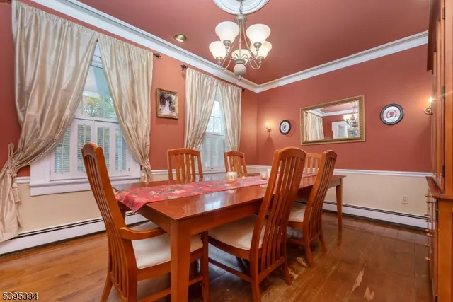 a dining room with furniture a chandelier and wooden floor
