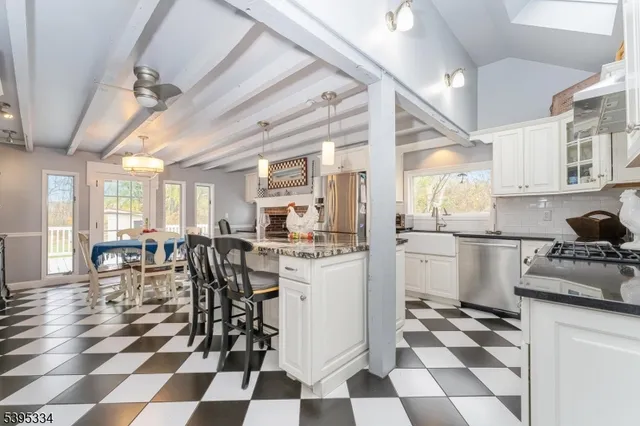 a kitchen with a checkered floor and white cabinets