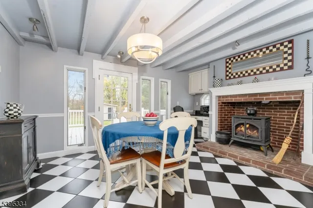 a dining room with a fireplace and a open kitchen view