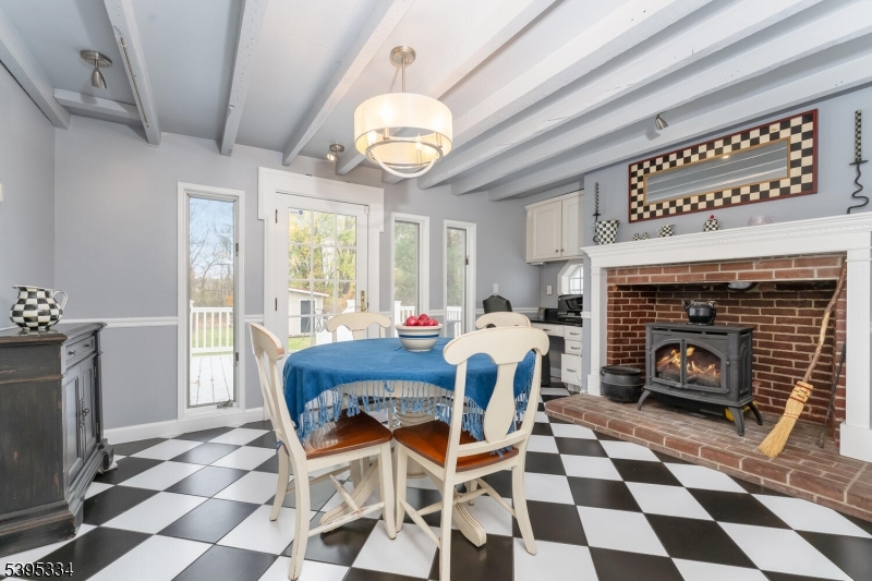 383 Pittstown Road Pittstown, NJ 08867 - Photo 8 of 29 a dining room with a fireplace and a open kitchen view