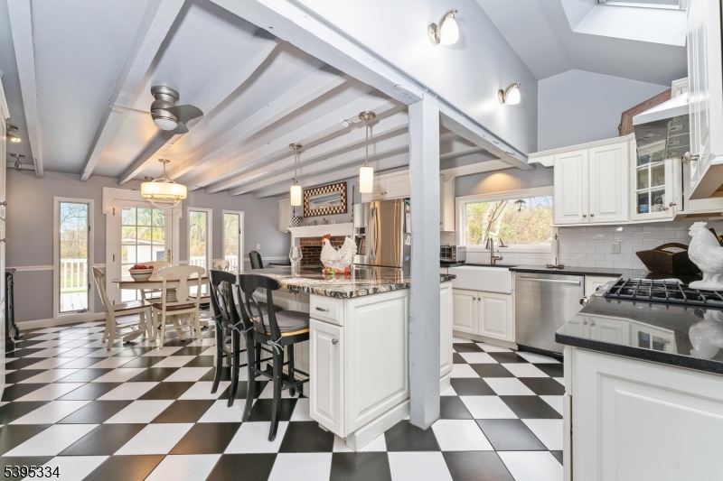 383 Pittstown Road Pittstown, NJ 08867 - Photo 9 of 29 a kitchen with a stove a chimney a dining table and chairs