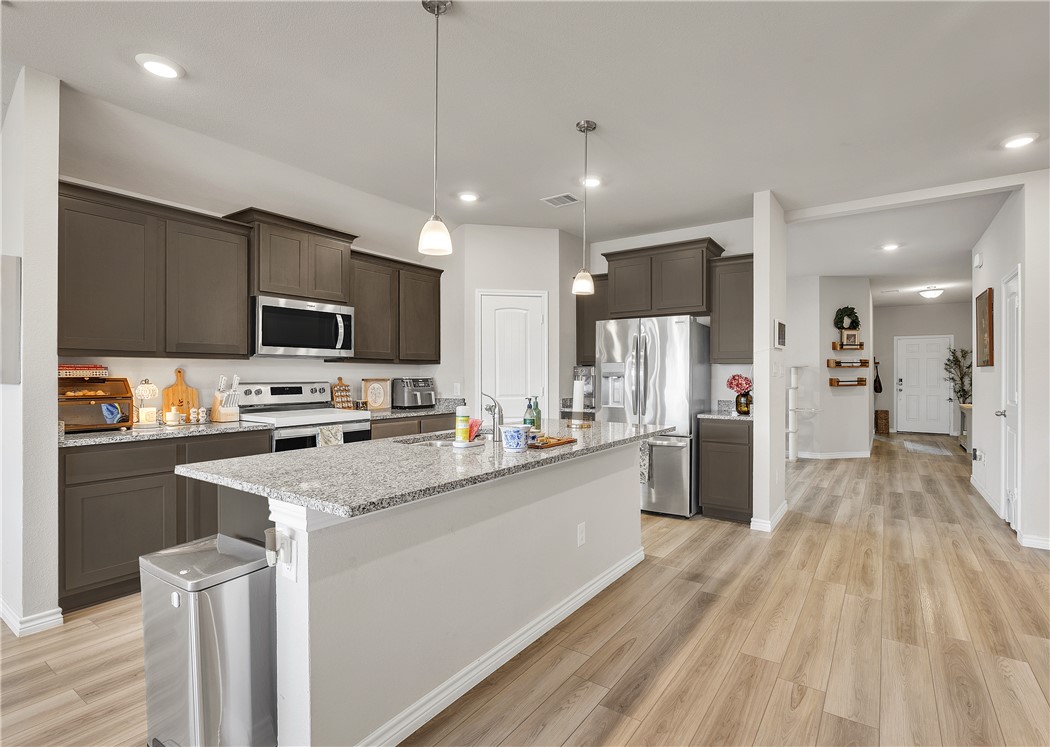 2016 Chief Street Bryan, TX 77807 - Photo 12 of 30 a kitchen with stainless steel appliances granite countertop a refrigerator a stove top oven a sink dishwasher and white cabinets with wooden floor