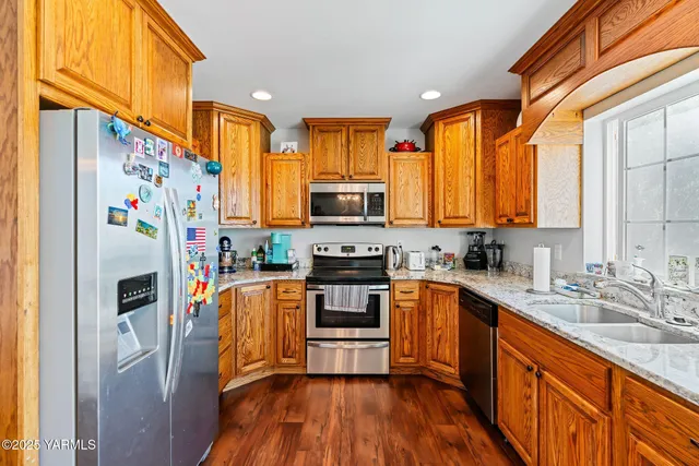 a kitchen with stainless steel appliances a stove a sink dishwasher a refrigerator and a microwave oven