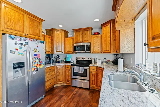 a kitchen with stainless steel appliances granite countertop a sink stove and refrigerator