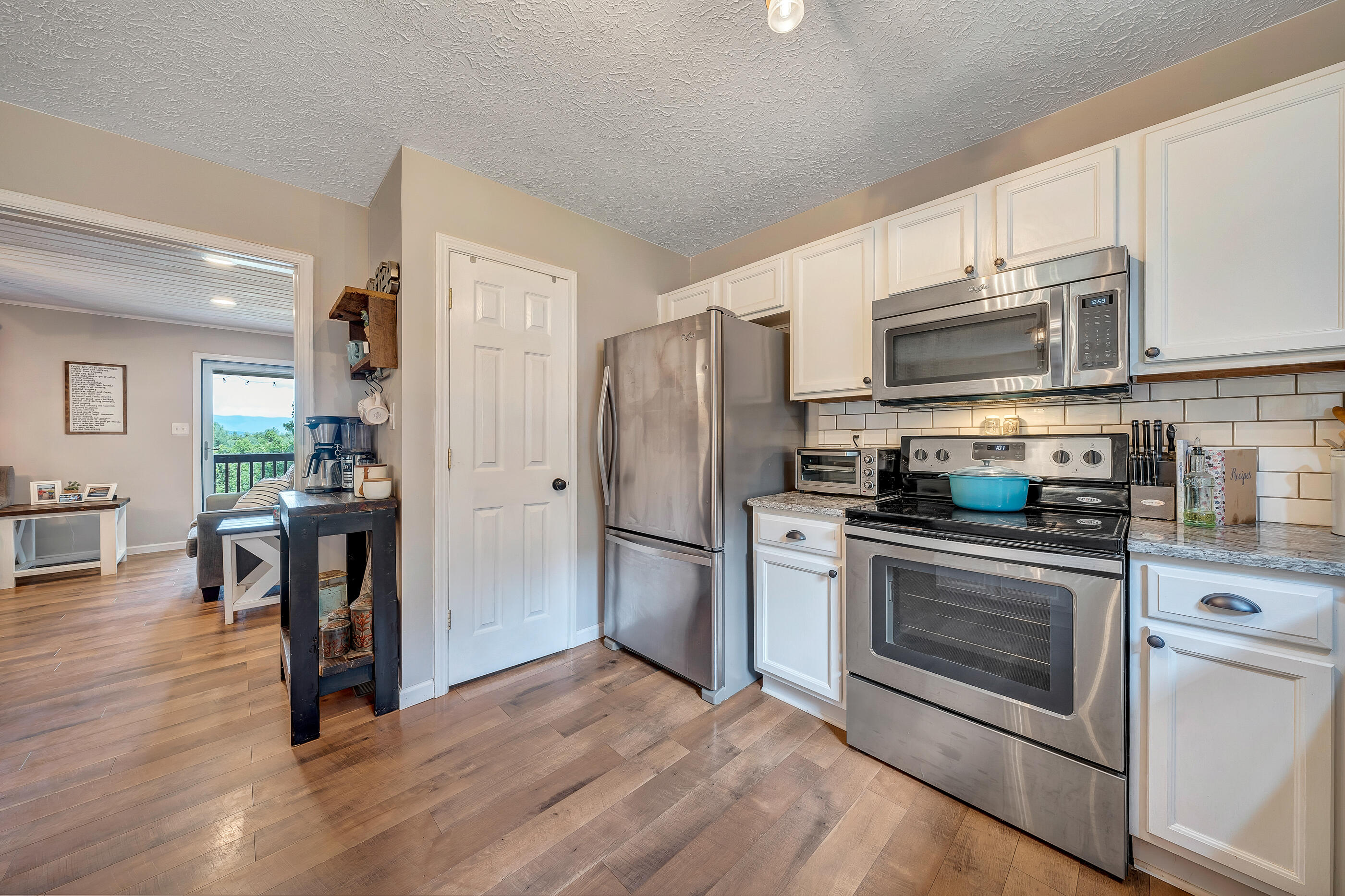 1145 Madcap Road Rocky Mount, VA 24151 - Photo 18 of 38 a kitchen with granite countertop wooden floors stainless steel appliances and center island
